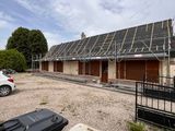 une voiture garée devant un immeuble dont le toit est équipé de panneaux solaires