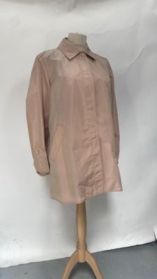 beige trench coat on a mannequin stand in front of a white backdrop