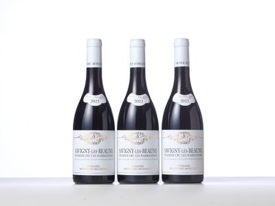 three bottles of red wine are lined up on a table