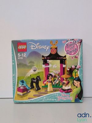 une boîte contenant des sets Lego « Princesses Disney » posée sur une table
