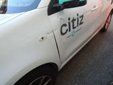 a white car with a green sticker on the side of it