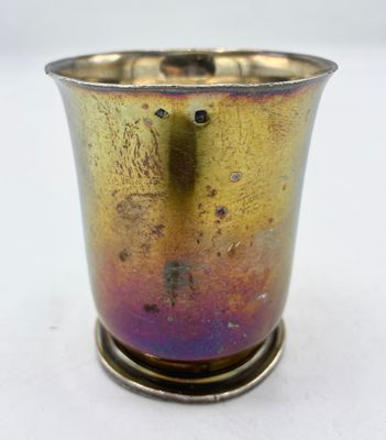 une tasse en métal posée sur un support