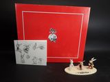 une boîte rouge sur laquelle se trouvent une petite figurine et une carte