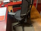 a red desk with a black chair and a computer on it