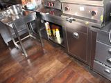 a large kitchen with stainless steel appliances and a wooden floor
