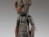une statue en bois représentant un homme à la grosse tête