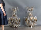 a woman standing in front of a wall of chandeliers