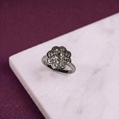 une bague en diamant posée sur une dalle de marbre blanc