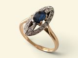 gros plan d'une bague avec un saphir bleu et des diamants