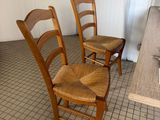 two wooden chairs sitting in a kitchen next to a sink
