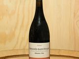 une bouteille de vin posée sur un tonneau en bois