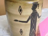 un vase sur lequel est représentée une femme en robe