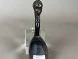 a black spoon sitting on a table next to a glass container
