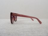 purple glasses on a white surface with a white wall in the background