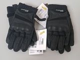 une paire de gants en cuir noir, encore étiquetés, posée sur une table