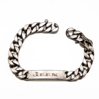 un gros plan sur un bracelet en argent sur lequel figure un prénom