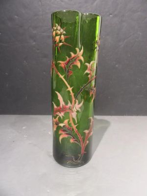 a green glass vase with red and yellow flowers on it