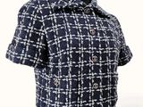 the back view of a woman ' s jacket with a collar and buttons