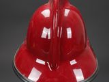 an image of a red fireman ' s helmet on a black base