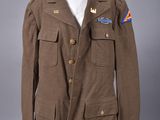 une veste marron avec un écusson bleu et rouge sur la poitrine