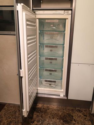 a refrigerator that is open in a small kitchen