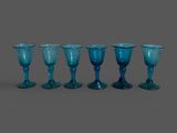 six verres à pied bleus sont alignés en rangée
