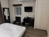 a bed with a white comforter and a flat screen tv on the wall