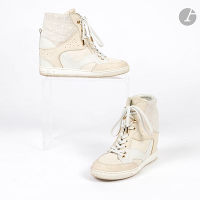 une paire de baskets blanches posée sur un socle en acrylique transparent, sur fond blanc