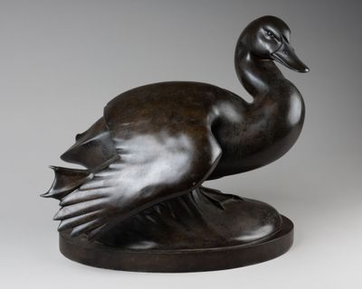 sculpture en bronze représentant un canard sur un socle, sur fond gris