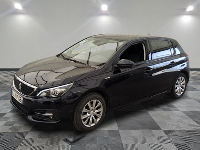 la voiture noire est garée sur un sol en damier dans le garage