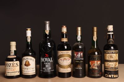 Des bouteilles de vin sont alignées sur une table devant un fond noir