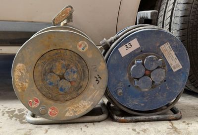 deux bobines métalliques posées par terre à côté d'une voiture