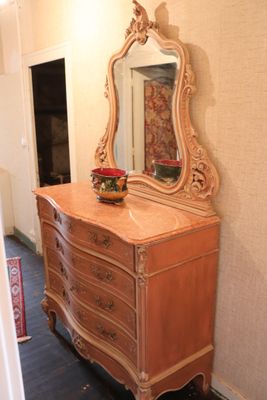 a dresser with a mirror on top of it in a room