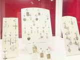 several pieces of jewelry displayed on a white table in a glass case