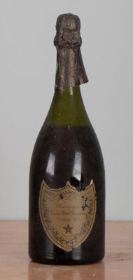 a bottle of champagne sitting on a table next to a bottle of wine