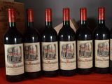 six bottles of red wine are lined up on a table