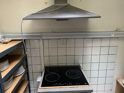 une cuisinière au milieu d'une cuisine, avec des assiettes sur le plan de travail