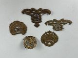 six insignes militaires anciens sont exposés sur un fond blanc
