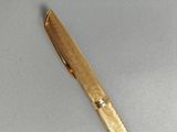 a gold pen that is laying on a table