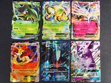 Des cartes Pokémon sont alignées sur une surface noire