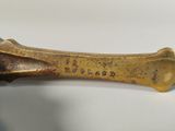 an antique brass dog bone with the word ' dog bone ' engraved on it