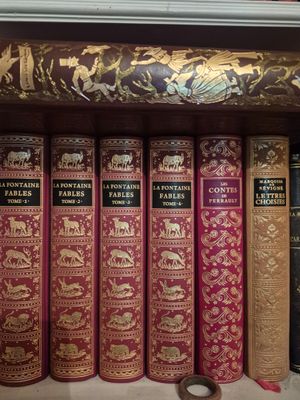 many books that are on a shelf in a library