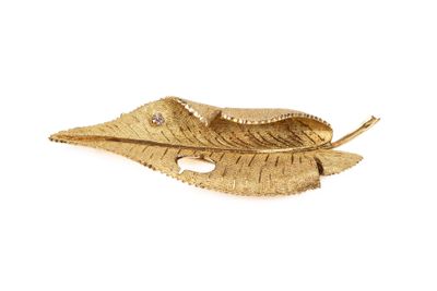 broche en feuille d'or avec un diamant au centre