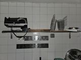 un mur carrelé de blanc, avec une étagère et un ventilateur