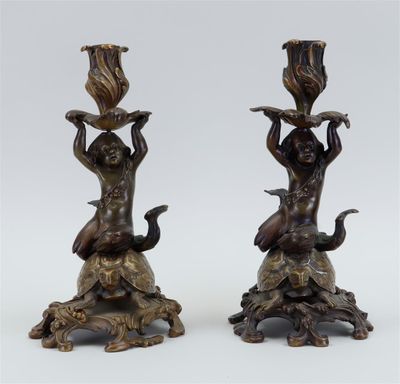 pair of bronze figurines of a boy and a girl on a rock