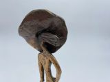 statue of a woman carrying a large rock on her back