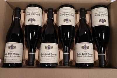six bouteilles de vin dans un carton sur une table
