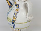 a white vase with a blue and yellow design on it