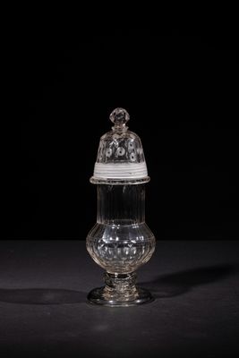 a clear glass jar with a lid on a black surface