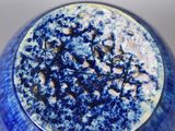 a close up of a blue and white vase on a table